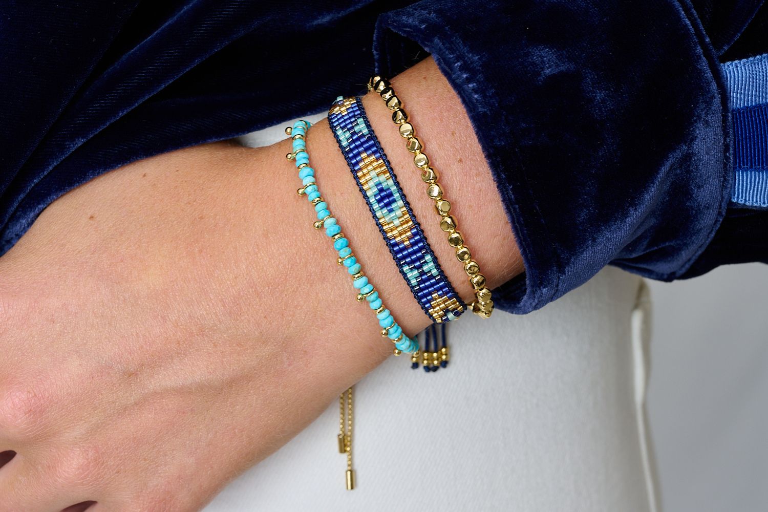 Close-up of a wrist wearing three beaded bracelets. Perfect bracelet layering sets from day to night
