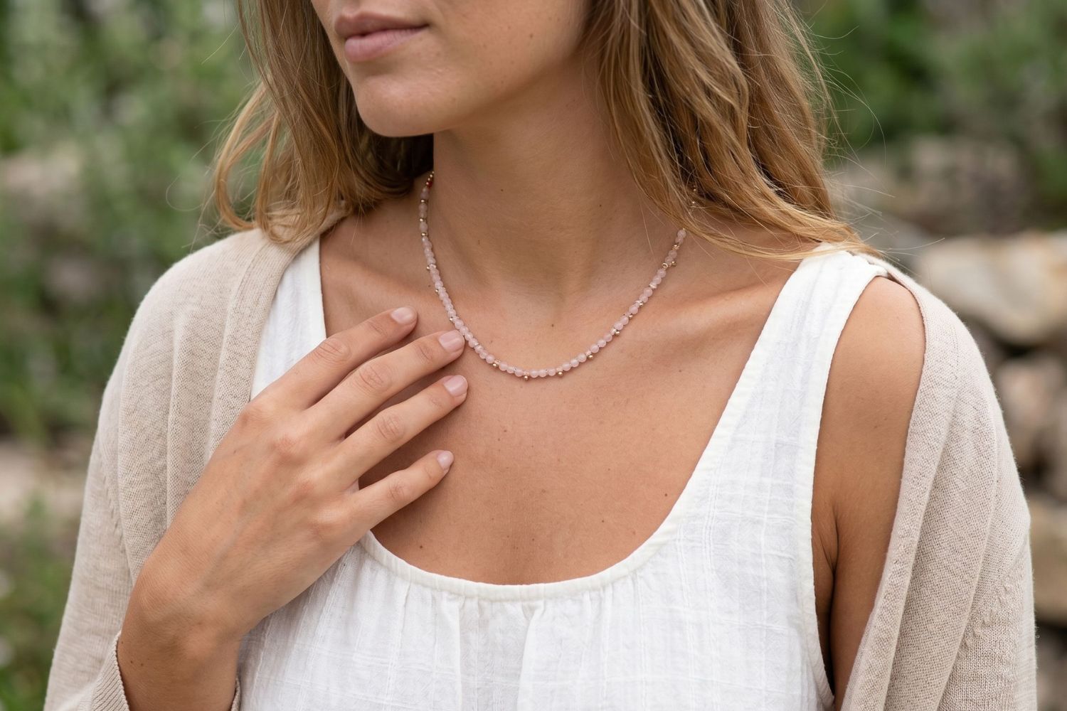 Salus Rose Quartz Gold Necklace styled around the neckline, showcasing natural rose quartz gemstones and waterproof gold PVD details designed for everyday wear and effortless layering.