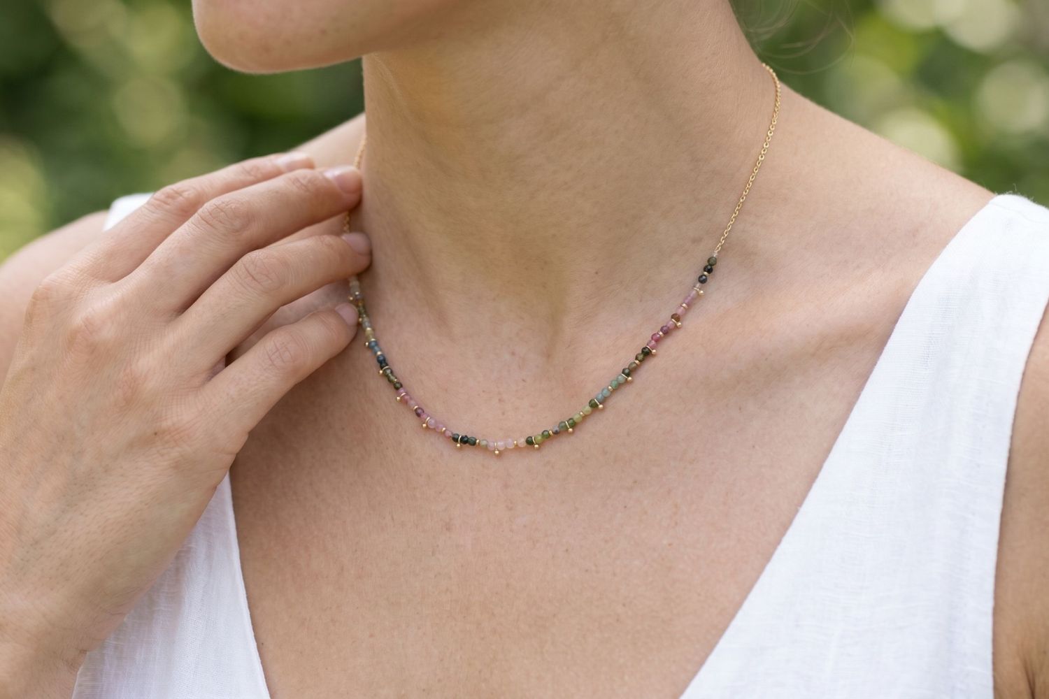 Salus Tourmaline Gold Necklace styled around the neckline, showcasing colourful natural tourmaline gemstones and waterproof gold PVD details designed for everyday wear and effortless layering.
