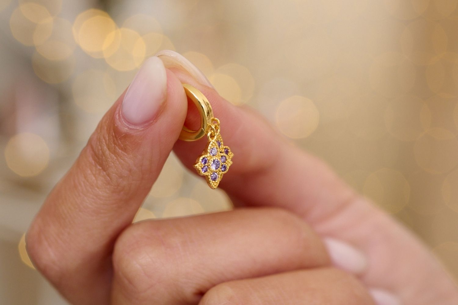 Close up lifestyle image showcasing the sparkle of the amethyst coloured CZ sterling silver Huggies. The perfect gift for girlfriend or Christmas Gift for her