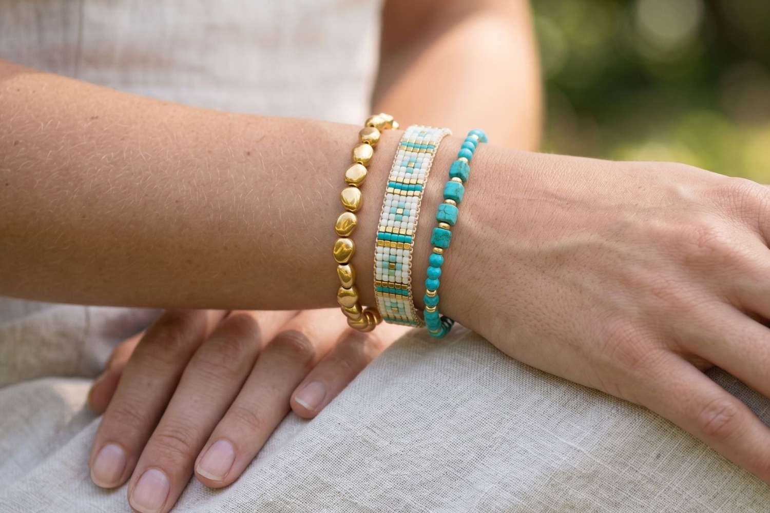 Antigua Turquoise and Gold Bracelet Stack styled on the wrist, showcasing turquoise howlite gemstones, gold bead textures and colourful woven bracelet detailing.