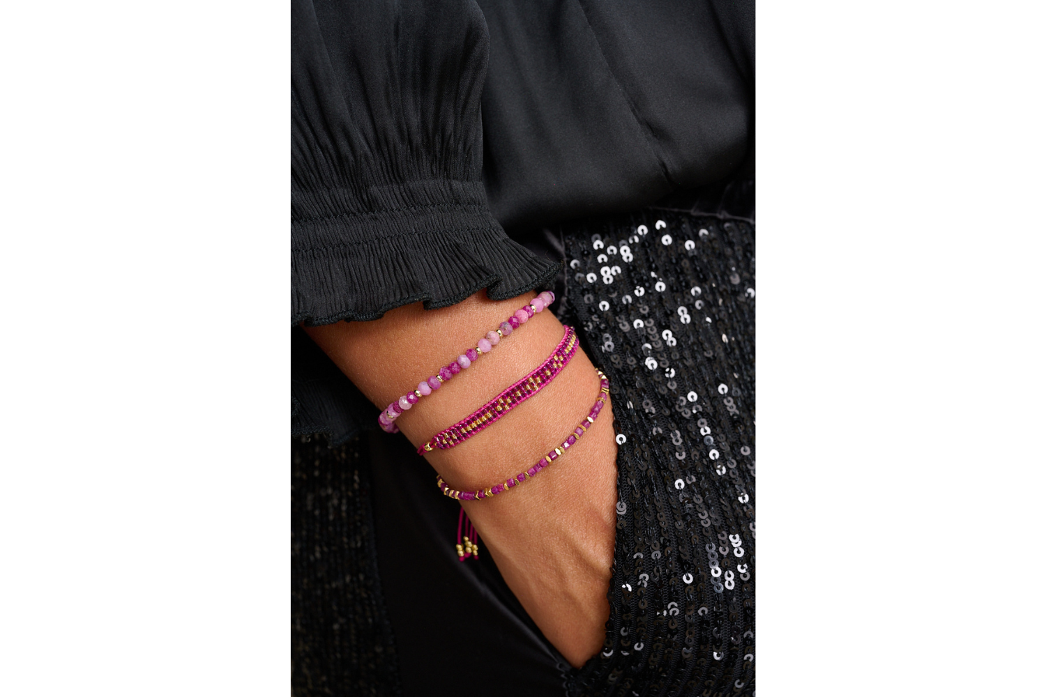 Aslan Raspberry Gold Friendship Bracelet styled on a wrist, showcasing its vibrant raspberry and gold iridescent Miyuki beads and effortlessly chic boho flair, perfect for layering.
