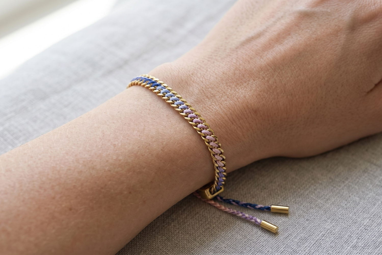Athena pink and lilac woven bracelet styled on the wrist, a soft pastel gold friendship bracelet perfect for stacking and everyday wear.