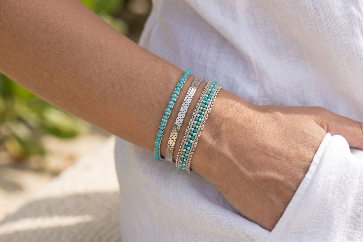 Azores Turquoise and Silver Bracelet Stack styled on the wrist, showcasing layered turquoise beads, silver slider bracelets and relaxed beach-inspired styling.