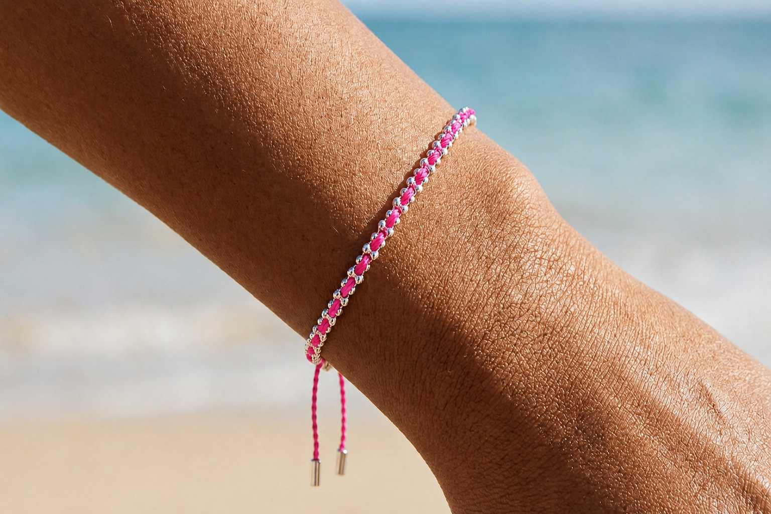 Braid Hot Pink Silver Bracelet styled on the wrist with bold pink cord and silver bead detailing for playful everyday stacking.