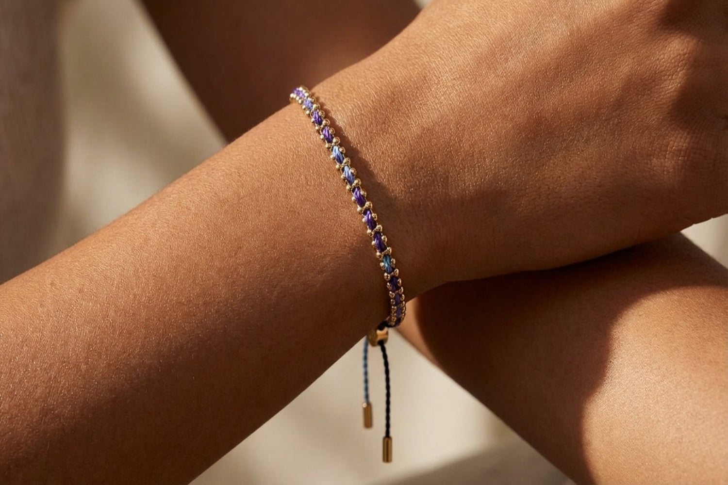 Delicate Braid Midnight Gold Woven Bracelet placed on a polished marble surface, highlighting craftsmanship and golden hues.