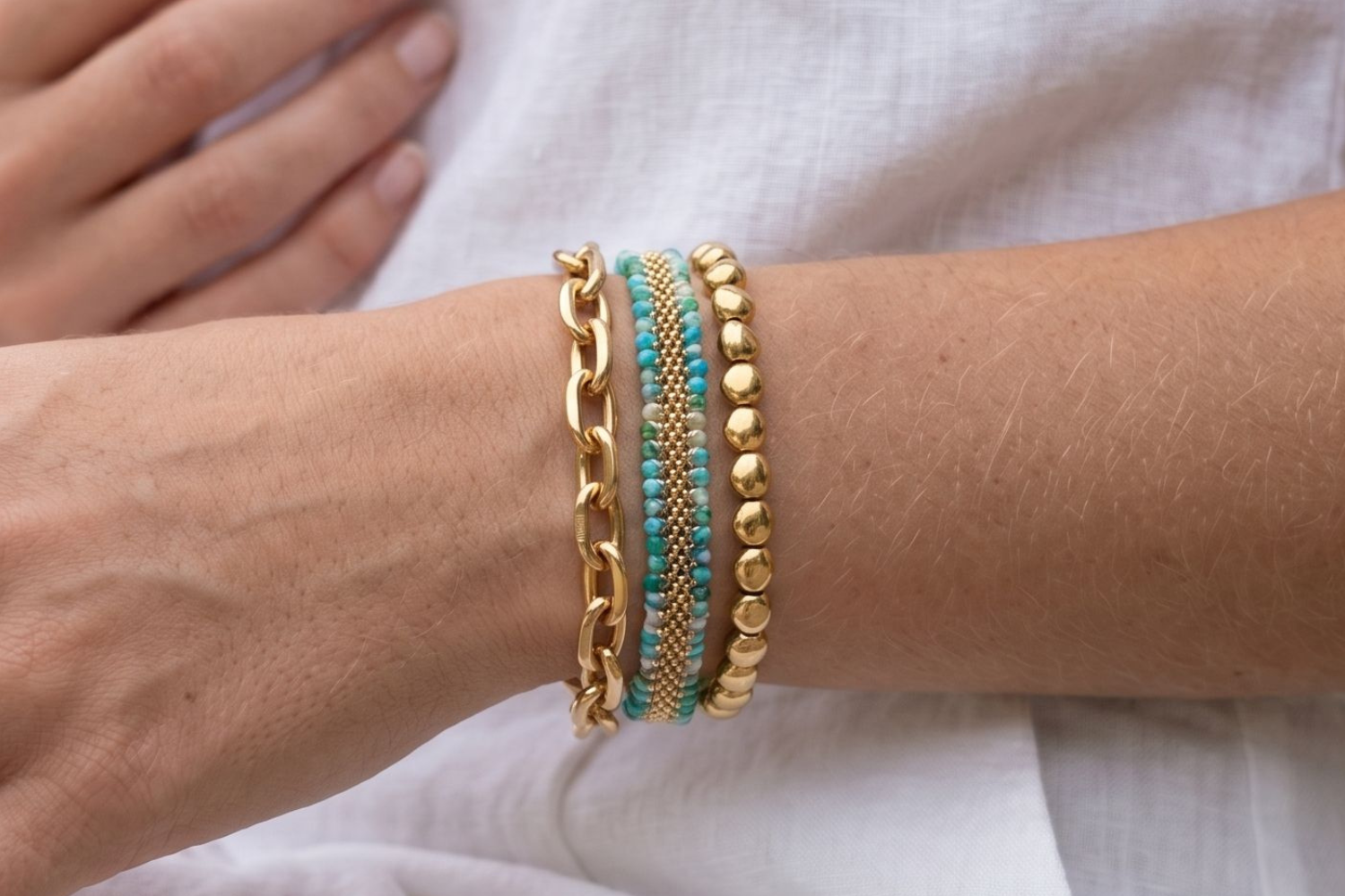 Caicos Amazonite and Gold Bracelet Stack styled on the wrist, showcasing amazonite gemstone beads, chunky gold chain textures and layered boho bracelet styling.