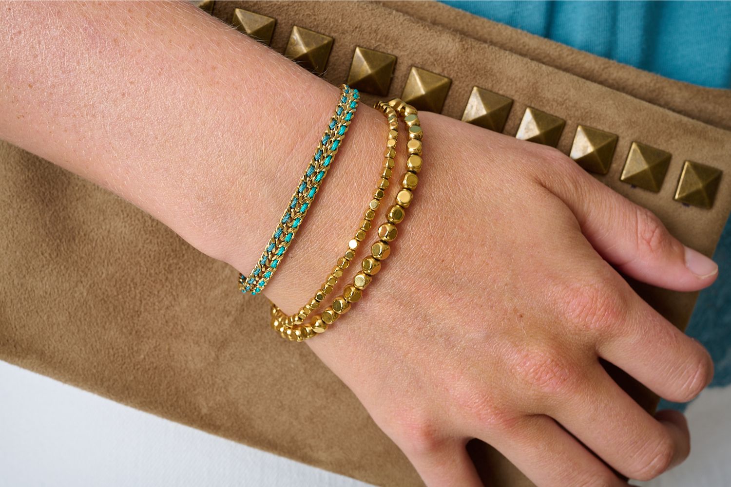 Cari Teal Gold Braided Bracelet styled on the wrist, evoking hidden lagoons with woven turquoise and navy threads, perfect for summer adventures and beach days.