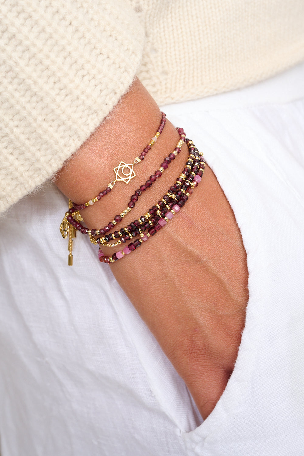 Cassia Garnet Bracelet styled with gold and gemstone bracelet layers in a rich, seasonal wrist stack with berry and golden tones.