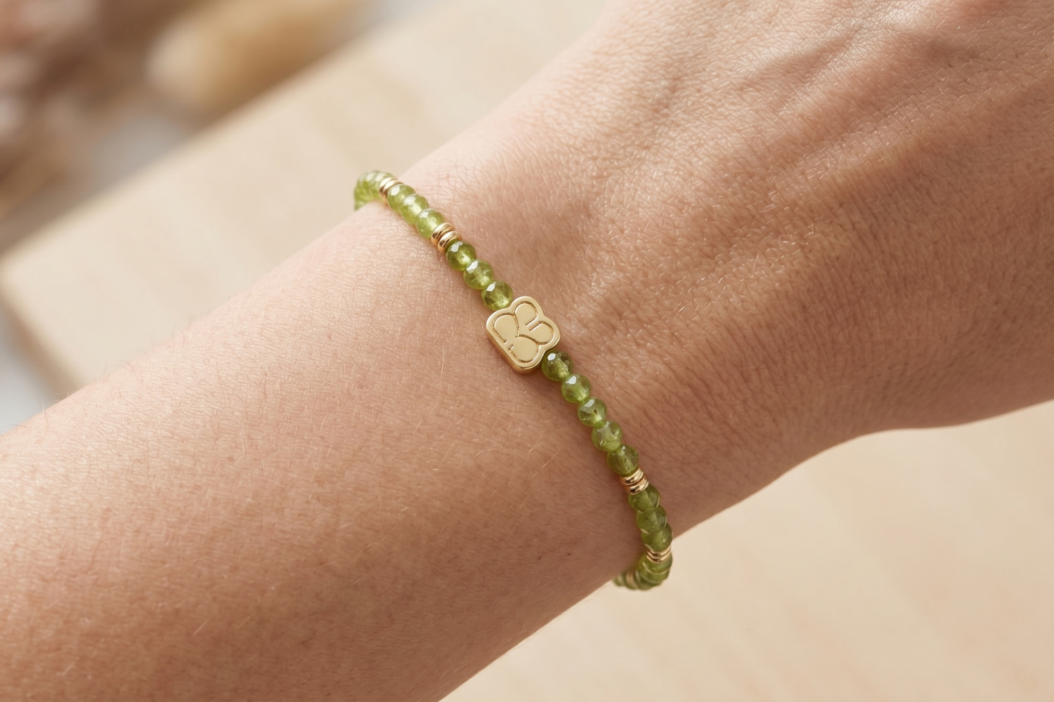 Close-up of a female wrist wearing a Wonder Gold Peridot Bead Bracelet highlighting tiny faceted beads and golden accents in natural lighting