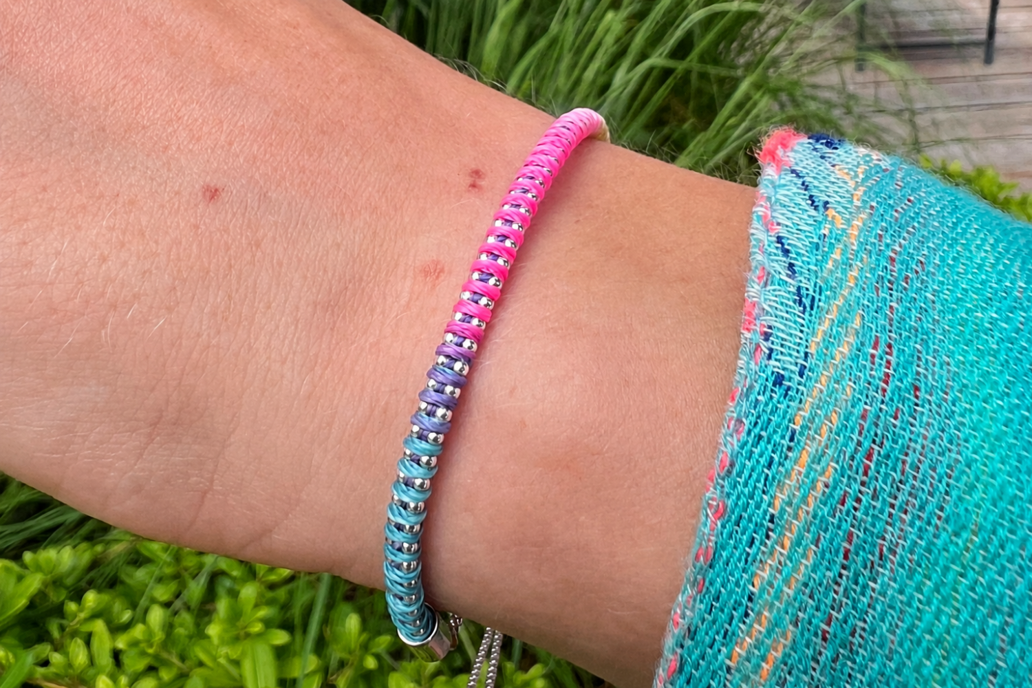 Emelia Havana Brights Silver Braided Bracelet styled on the wrist, showcasing vibrant woven threads and white gold PVD details for effortless summer layering.