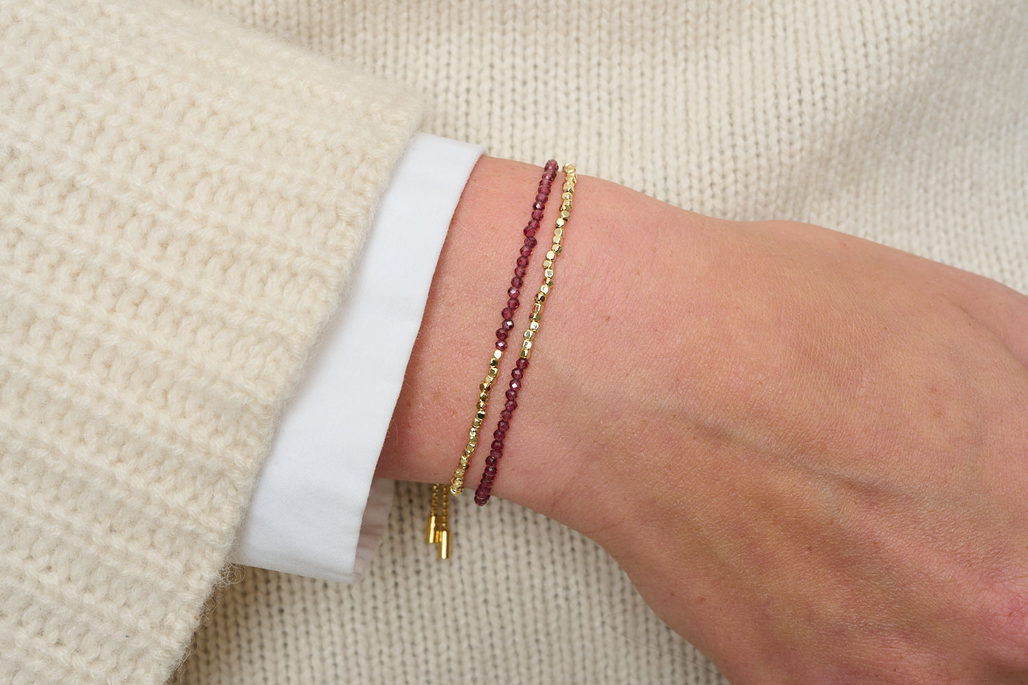 Juniper Garnet & Gold Double Strand Bracelet featured on wrist with Boho Betty stacking bracelets in gold and garnet gemstone tones.