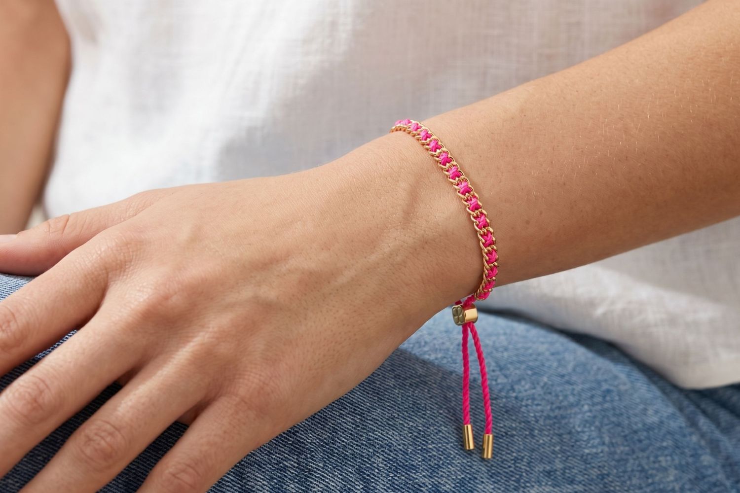 Lilia Gold & Hot Pink Woven Bracelet styled on the wrist, showcasing bold pink woven detailing and warm gold accents for playful boho styling.