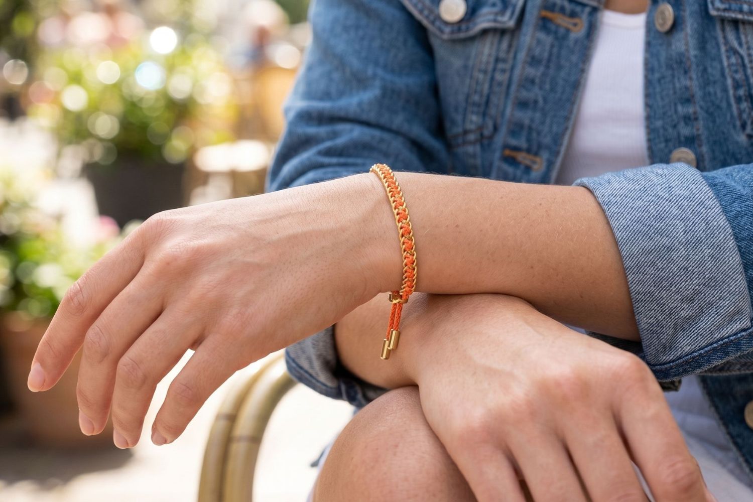 Lilia Gold & Neon Orange Woven Bracelet styled on the wrist, showcasing bold neon woven detailing and warm gold accents for playful boho styling.