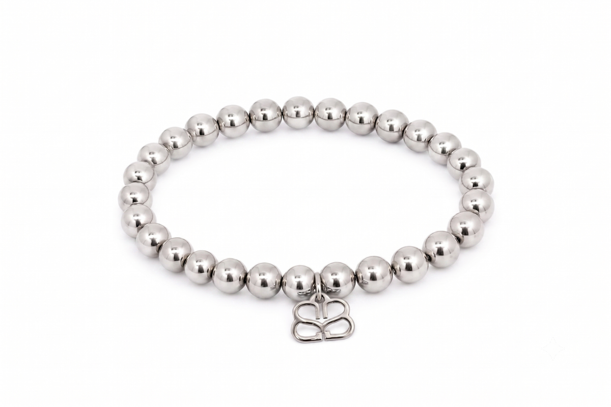 Lissette Silver Bead Stretch Bracelet featuring smooth polished silver-tone beads, Boho Betty’s signature BB filigree charm and waterproof White Gold PVD-coated stainless steel.
