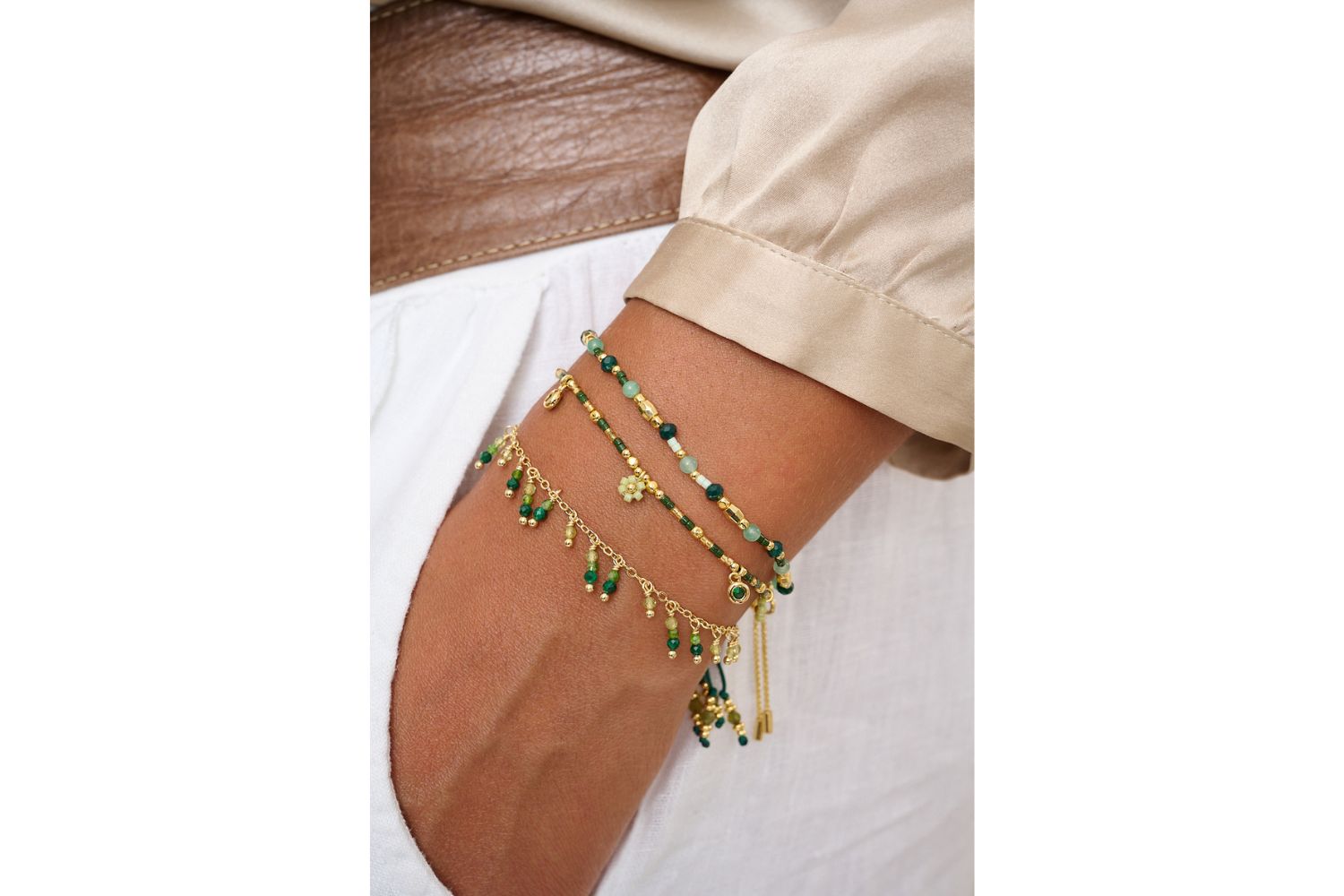 Wrist stack featuring the Rania Green & Gold Beaded Charm Bracelet styled with earthy tones and gold accents for a grounded boho vibe.