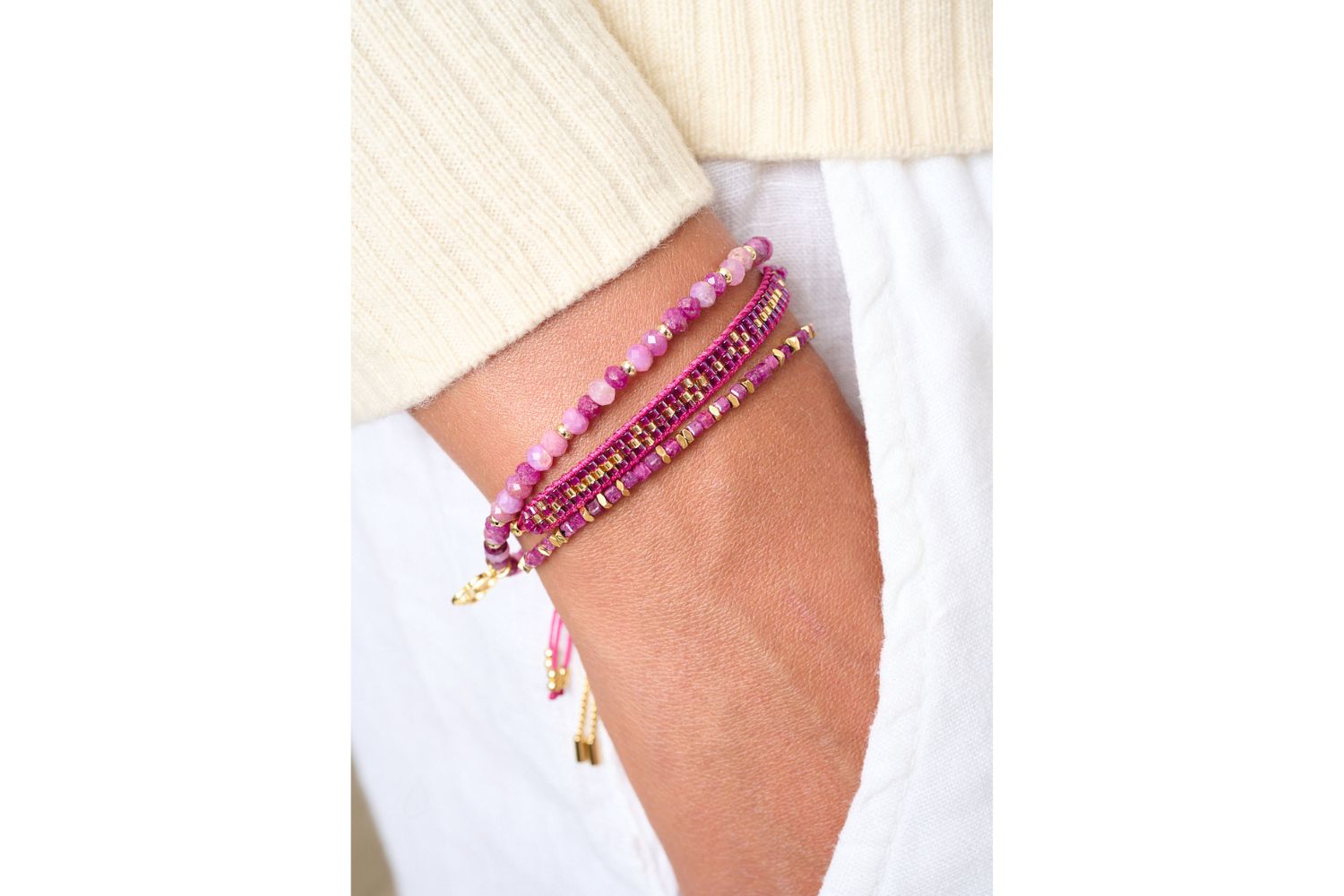 Vik Ruby Gold Bracelet Stack styled on the wrist, showcasing vibrant ruby stones, gold accents, and woven textures for a bold layered look.