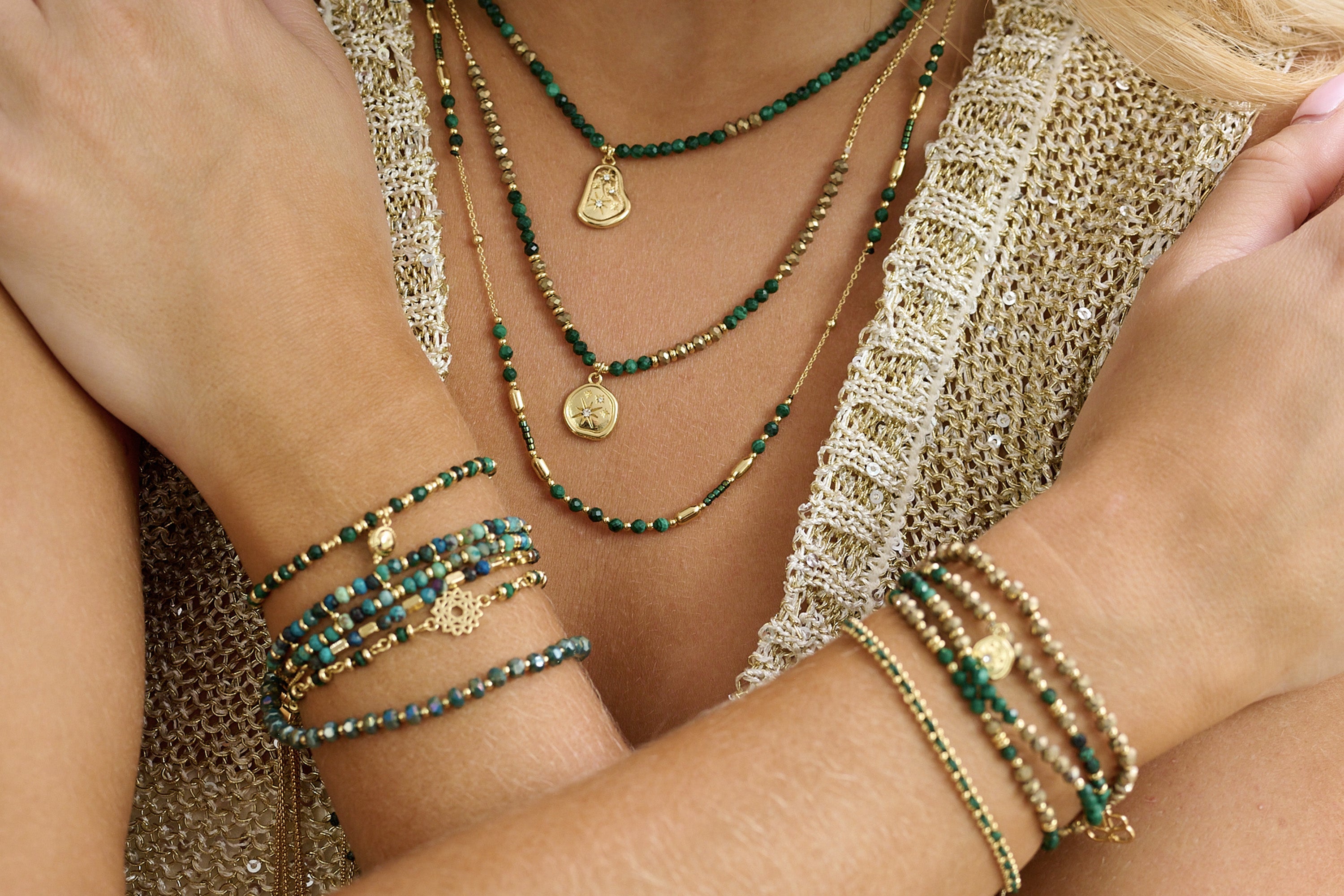 A lifestyle shot showcasing Verde Malachite Bracelet and Allat Malachite necklace layered with lots of stacking bracelets and necklaces - Boho Betty