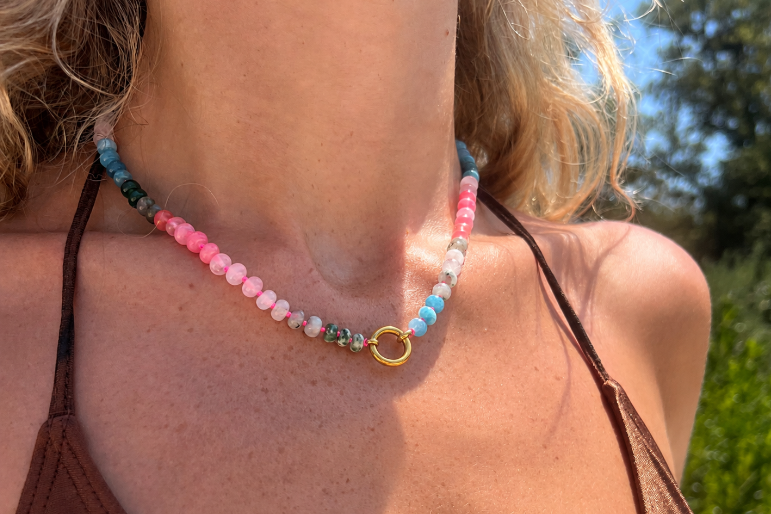 Model wearing the Amala Pink & Blue Gold Charm Carrier Necklace featuring colourful jade, rose quartz and labradorite gemstone beads with a waterproof 14k gold PVD charm carrier clasp.