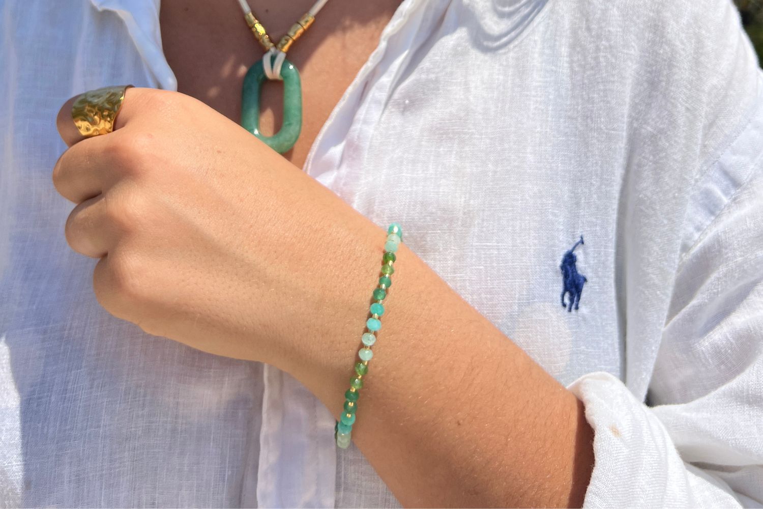 Model wearing the Araminta Gold & Aqua Gemstone Bead Bracelet featuring jade gemstones, gold Miyuki bead accents and a waterproof 14k gold PVD slider fastening.