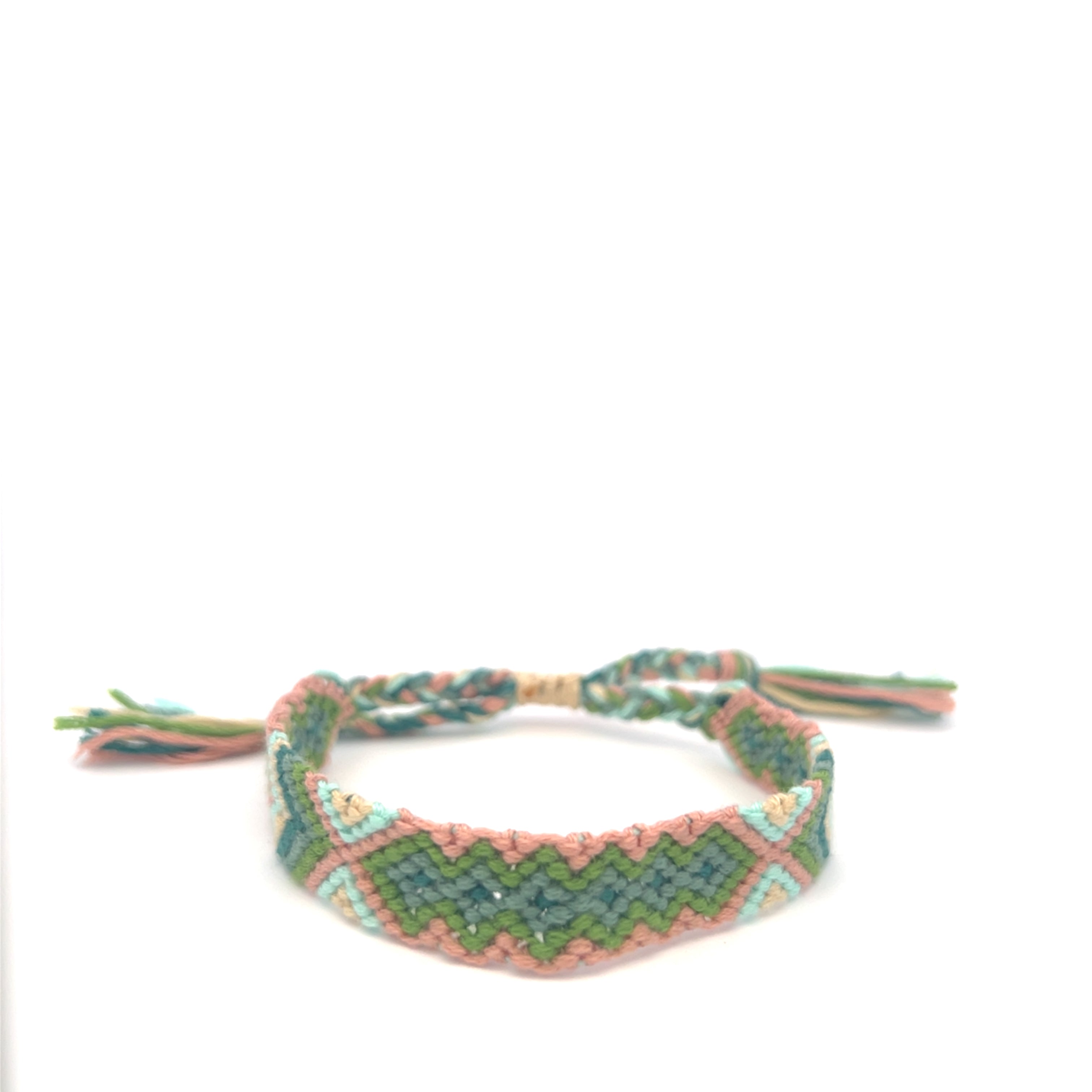 Braided bracelet with pink and green pattern on a white background #color_green