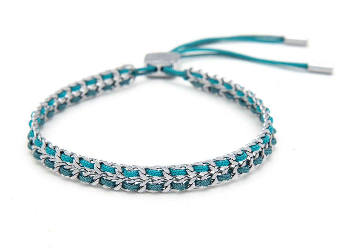 Cari Teal Silver Braided Bracelet with turquoise and navy woven threads, a beach-ready accessory perfect for adding coastal elegance to any look.