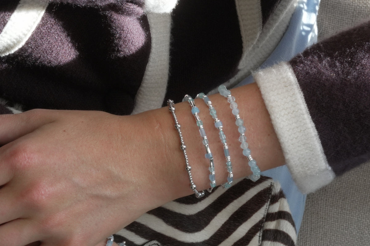 Wonder silver and blue topaz stretch bead bracelet by Boho Betty – styled in a stack, a blue topaz beaded stretch bracelet