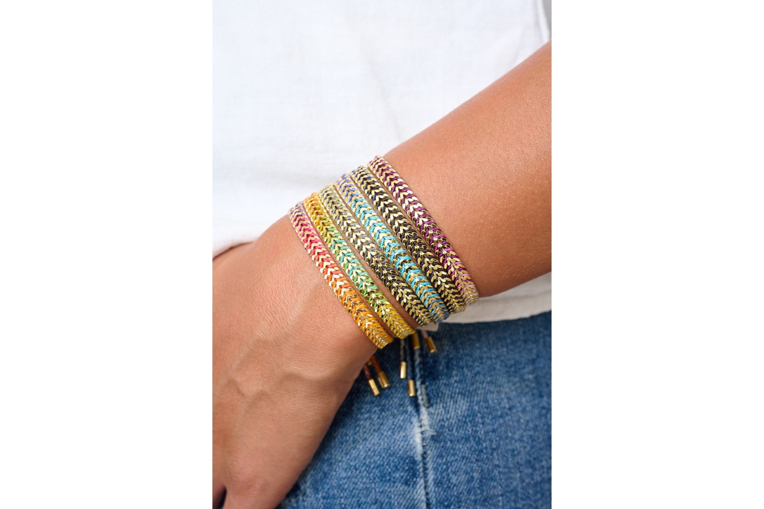 Iztac Blue & Gold Ombre Braided Bracelet styled on the wrist, showcasing ombre purple threads and shimmering gold chevron details.