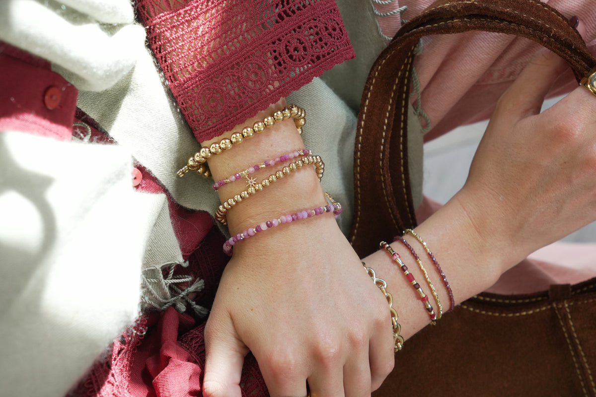Rue gold and ruby bead bracelet by Boho Betty – styled in a stack, a gold ruby gemstone beaded slider bracelet