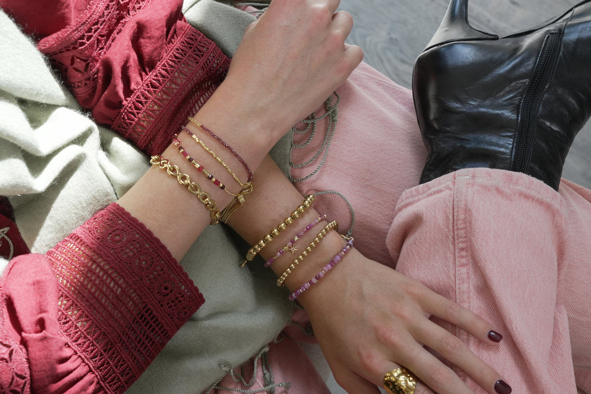 Una ruby mix gold star charm bracelet by Boho Betty – styled in a stack, a gold ruby gemstone star charm slider bracelet