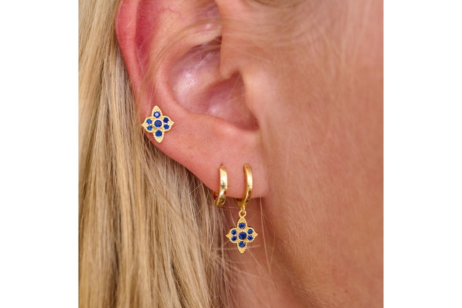 Stunning lifestyle picture showcasing the simple elegant Reddy gold plated hoop buggy nested in-between the Theron Sapphire coloured CZ drop earrings and Takia Sapphire coloured sterling silver stud Earrings. The perfect Christmas gift for teens or Christmas gifts for a daughter 