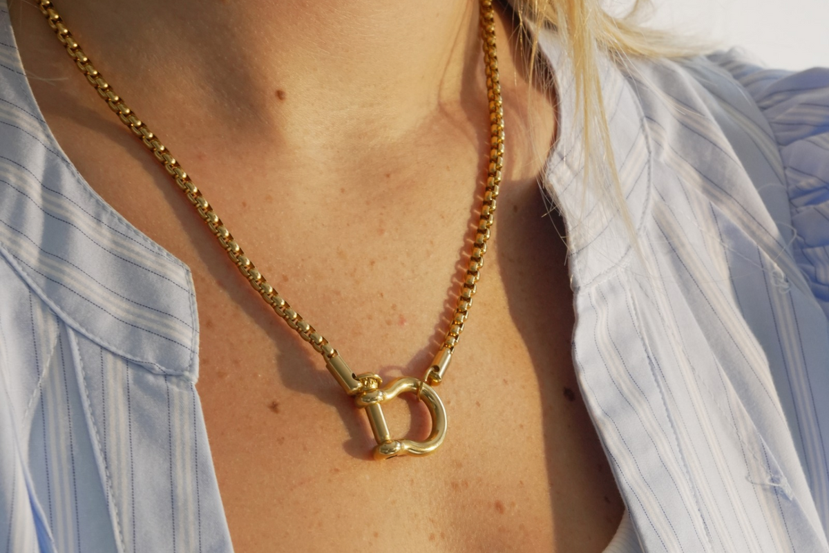 Rosalind Gold Charm Carrier Necklace worn layered with a polished horseshoe charm carrier on a waterproof 14k Gold PVD stainless steel chain, styled with personalised charms.