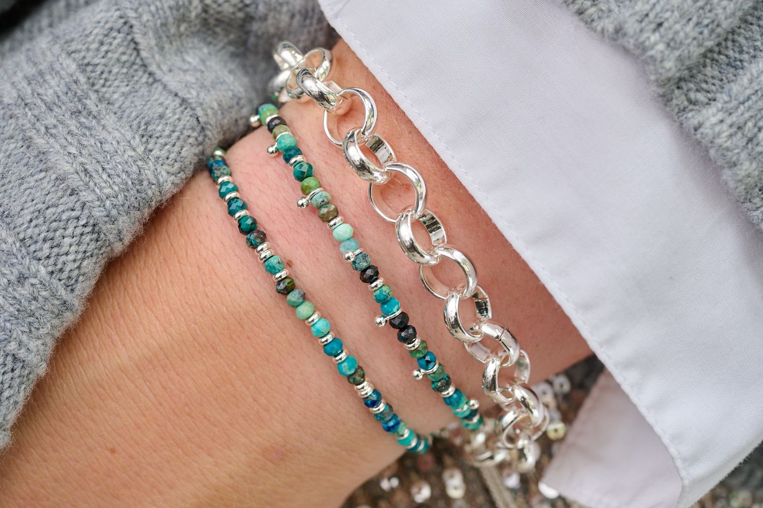 set of three bracelets, two with green/blue azurite beads and the other a silver chunky chain bracelet, shot on model