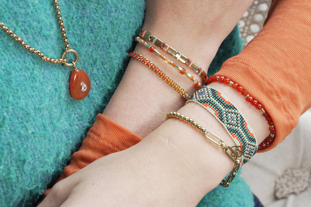 Chiara gold and orange agate gemstone bracelet by Boho Betty – styled in a stack, a gold orange agate beaded slider bracelet