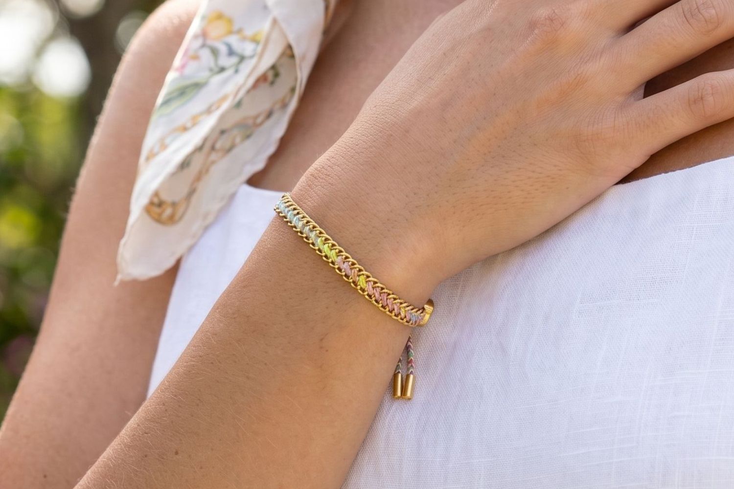 Athena Gold and Sorbet Rainbow Braided Bracelet styled on the wrist, showcasing colourful pastel woven detailing and waterproof gold PVD accents for playful summer styling.