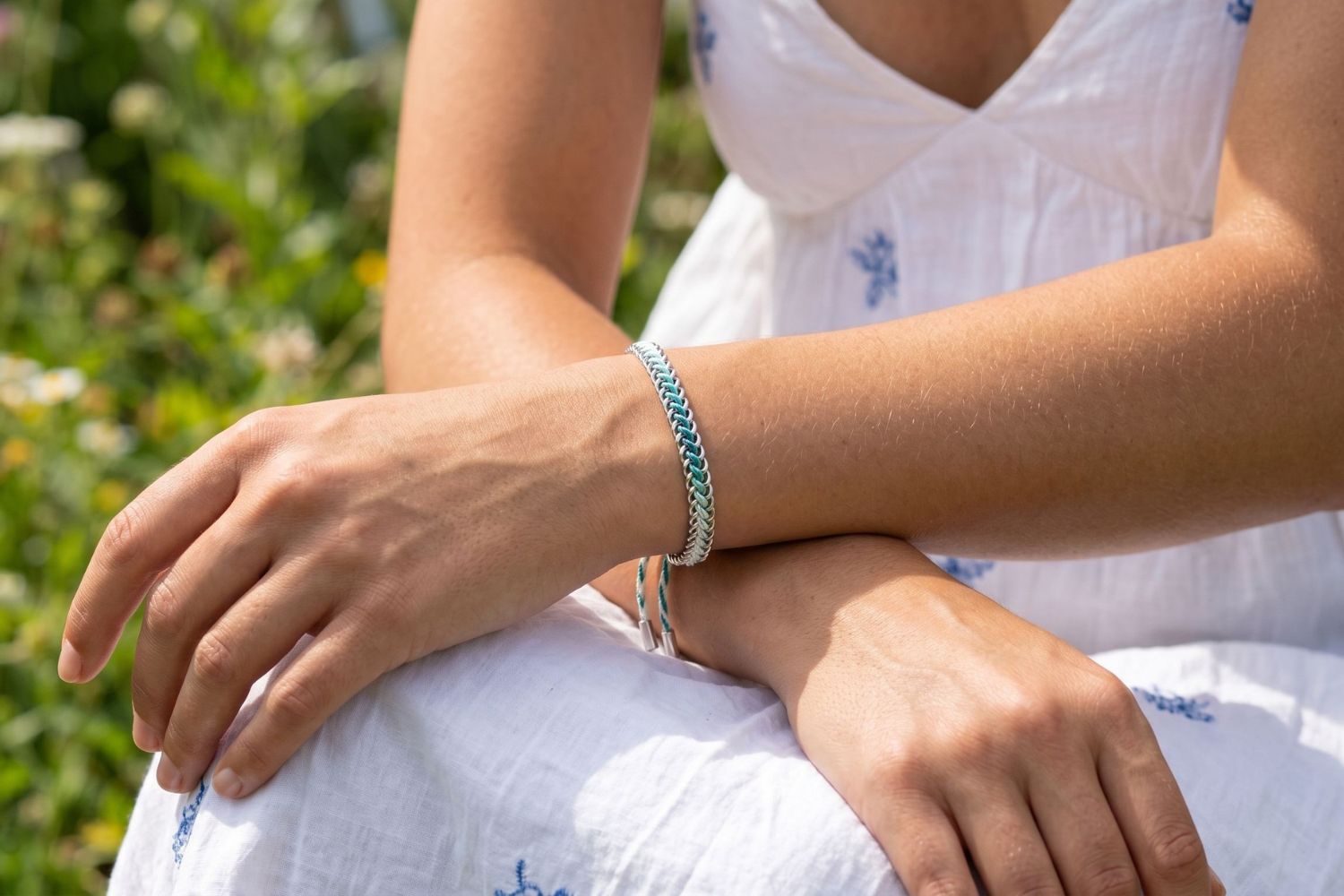 Athena Silver & Turquoise Braided Bracelet styled on the wrist, showcasing turquoise woven detailing and waterproof silver PVD accents for fresh coastal styling.