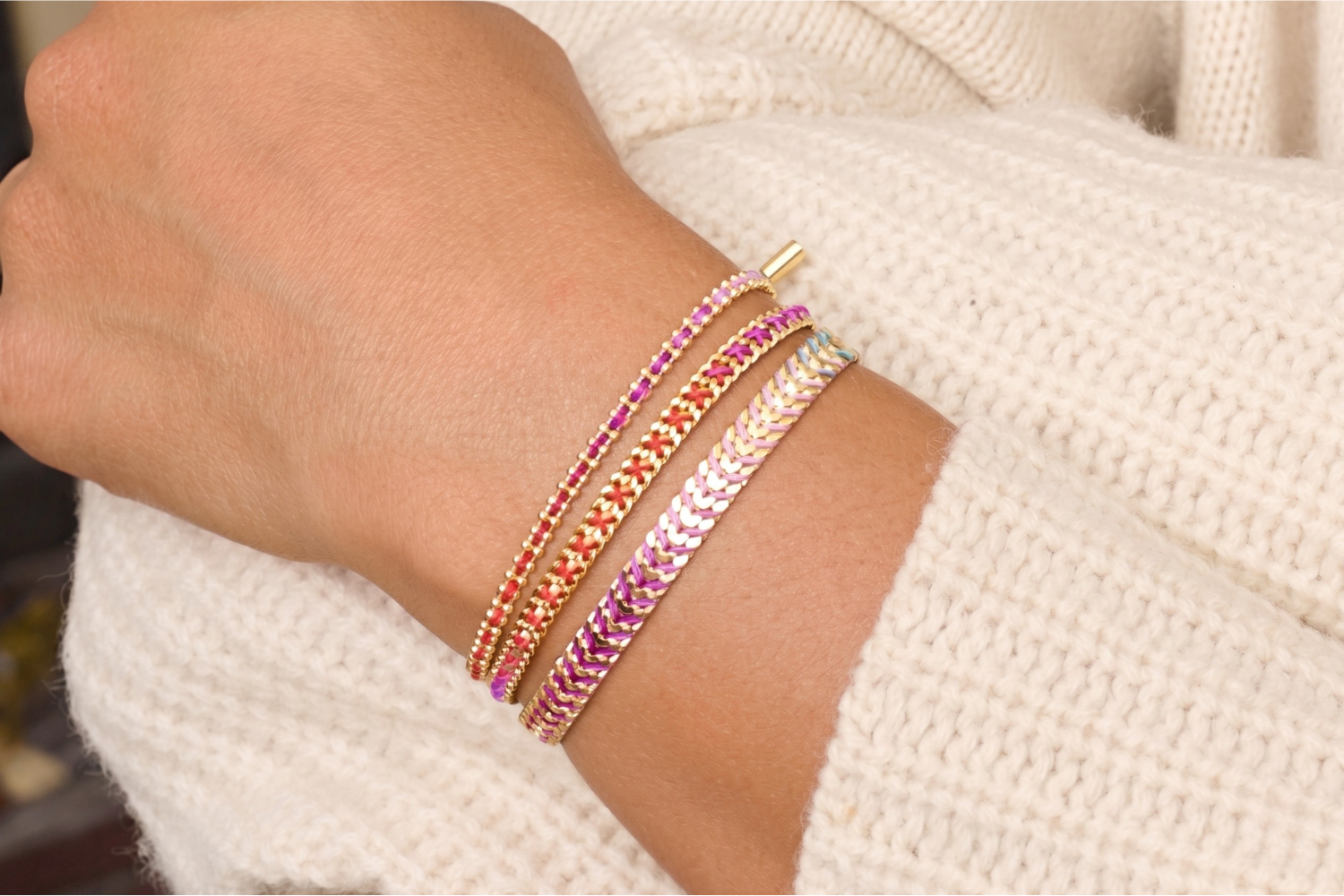 Banda Moroccan Spice Gold Bracelet Stack styled on the wrist, showcasing layered woven bracelet designs in vibrant sunset-inspired colours with warm gold accents.