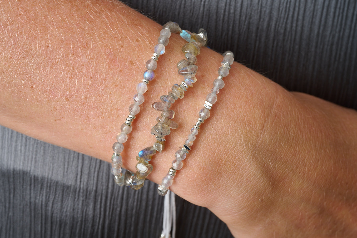 Bliss Labradorite & Silver Adjustable Bracelet styled on the wrist, showcasing its shimmering labradorite gemstones, silver accents, and boho-inspired adjustable slider fastening.