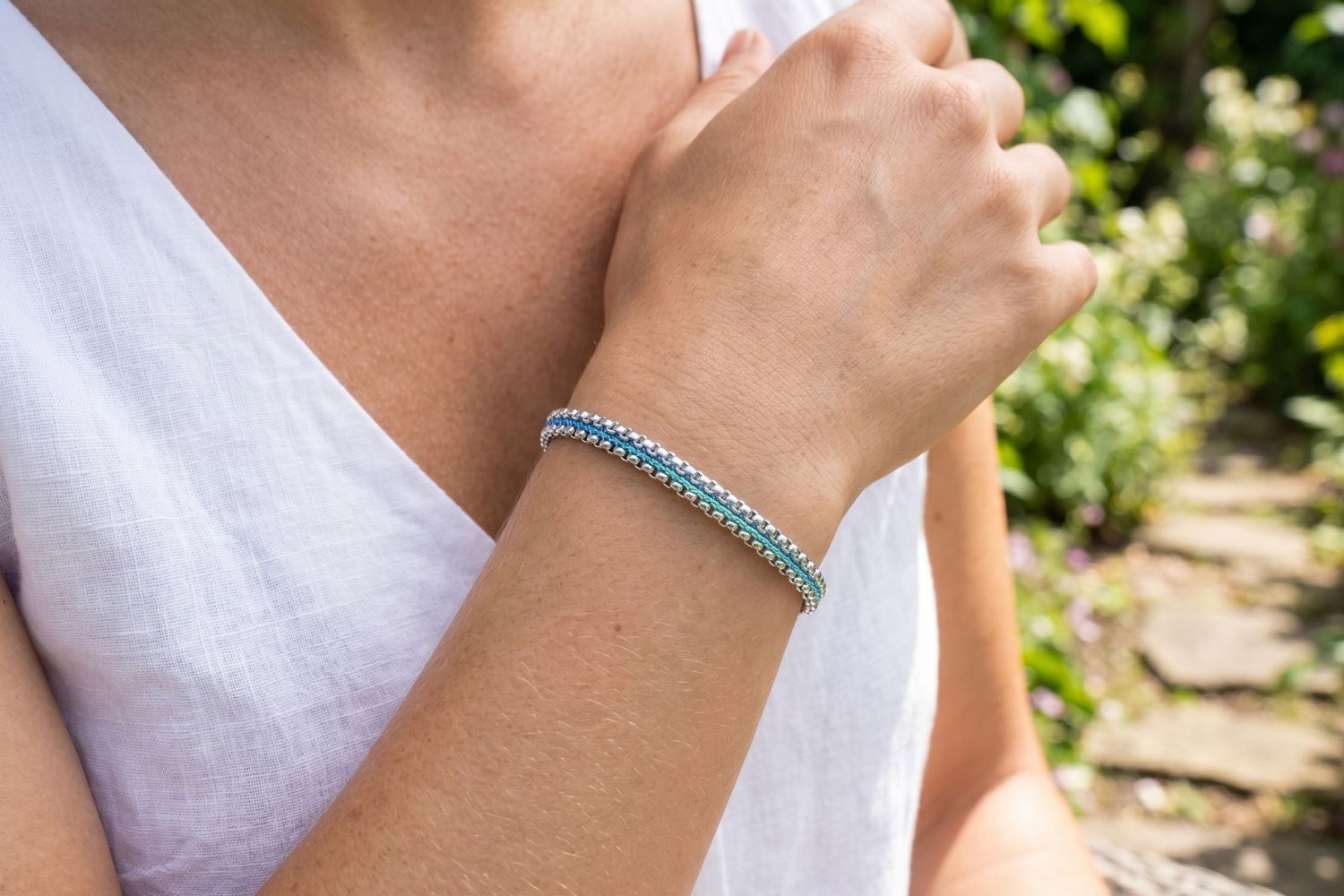 Bloom sky blue woven bracelet styled on the wrist, a cool-toned silver friendship bracelet perfect for stacking and everyday wear.