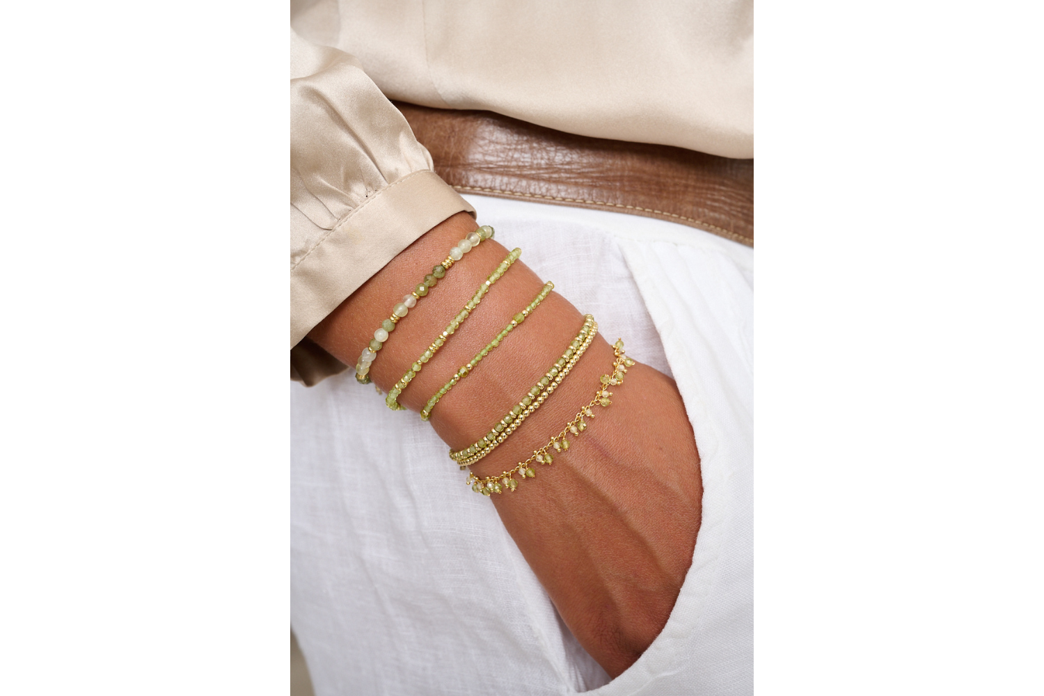 Bluebell Gold & Peridot Stretch Bead Bracelet styled on the wrist, showing layered peridot beads and gold accents in a soft, beachy summer look.