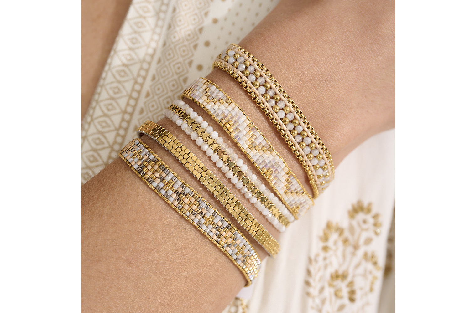 Claudia White Gold Friendship Bracelet styled on the wrist, featuring soft neutral tones and gold accents, perfect for layering or wearing solo.