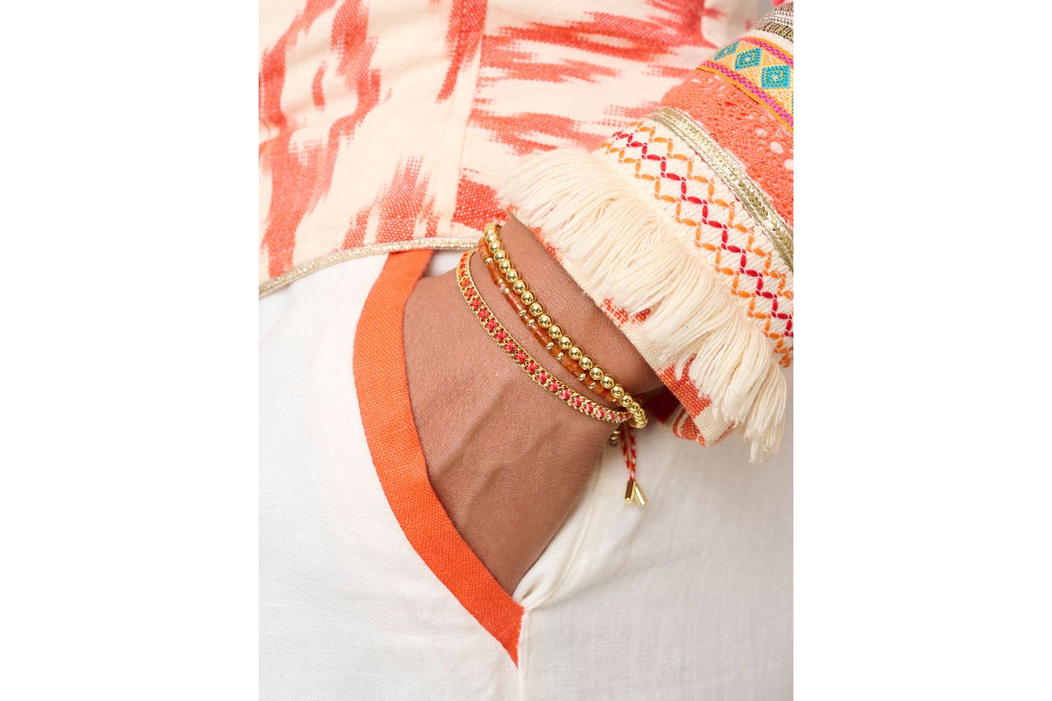 Cocos Gold & Red Agate Bracelet Stack styled on the wrist, glowing with red agate beads, golden accents, and sunset-inspired woven texture.