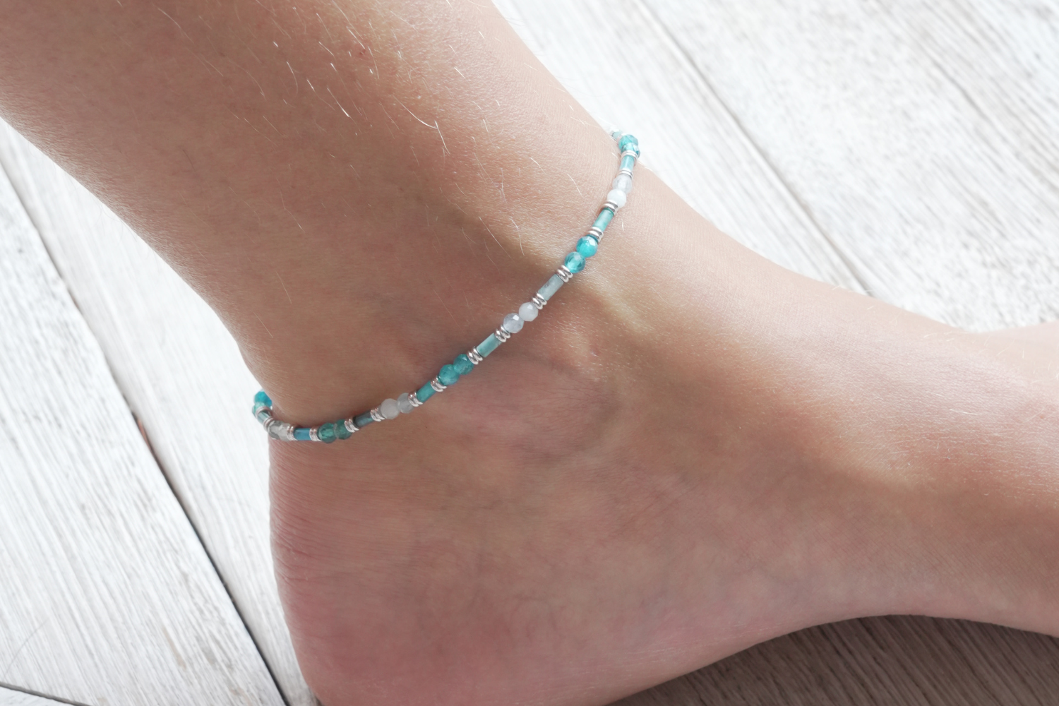 Coralie Apatite & Aquamarine Silver Gemstone Anklet worn around the ankle with natural Apatite and Aquamarine gemstones and a waterproof white gold PVD stainless steel chain.