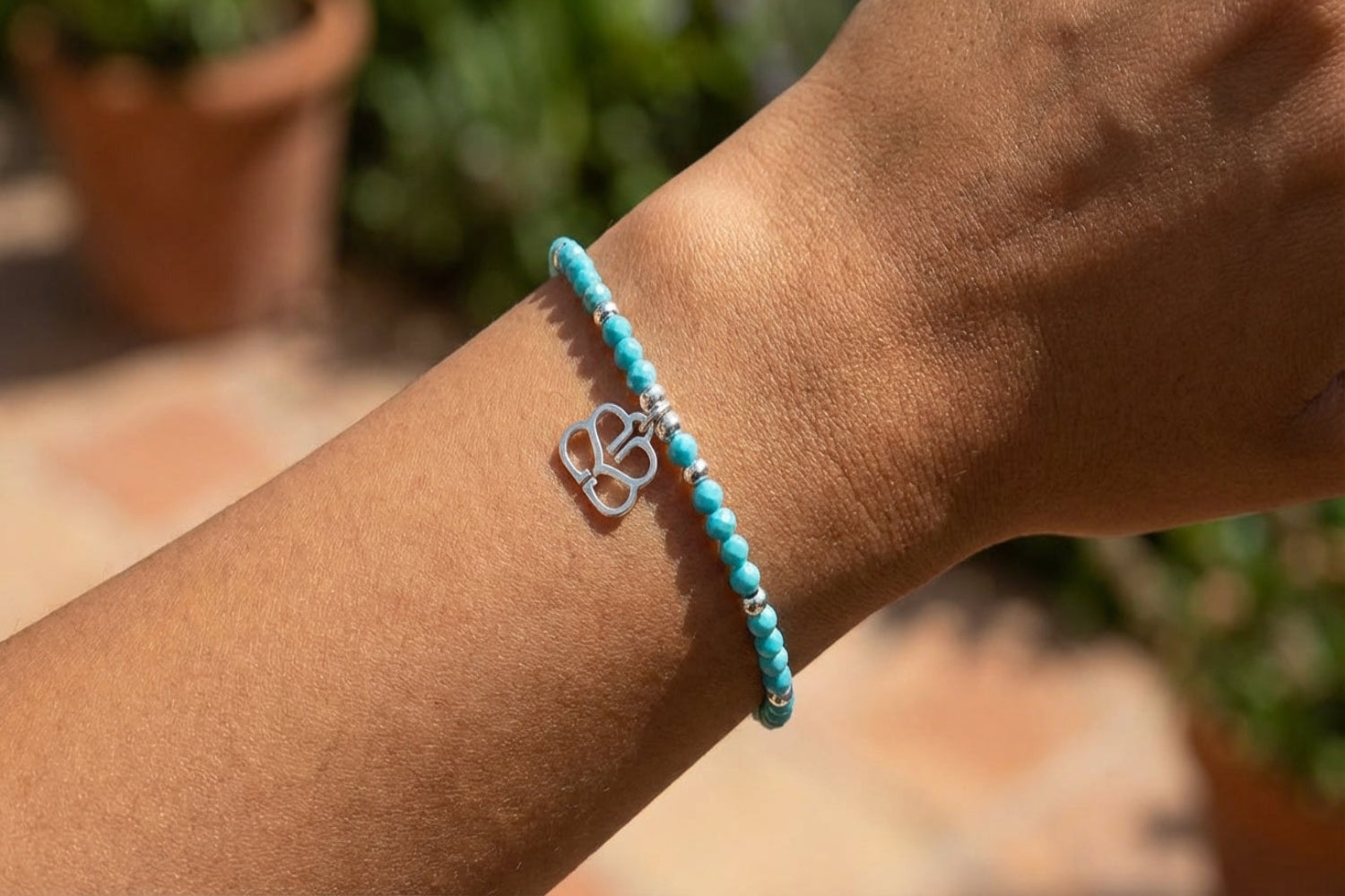 Close-up of a woman's arm with the turquoise howlite bead bracelet, showcasing its delicate design and natural skin tone.