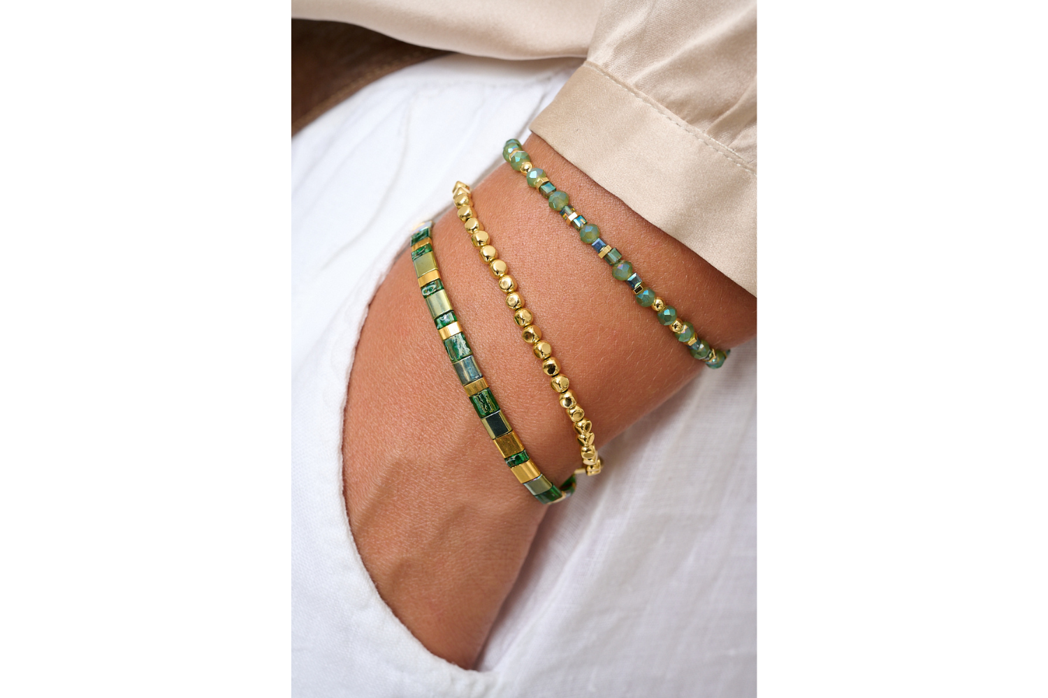 Dawn Gold & Green Crystal Bead Bracelet styled on the wrist, catching the light with shimmering green and blue tones and warm gold accents—ideal for stacking or wearing solo.