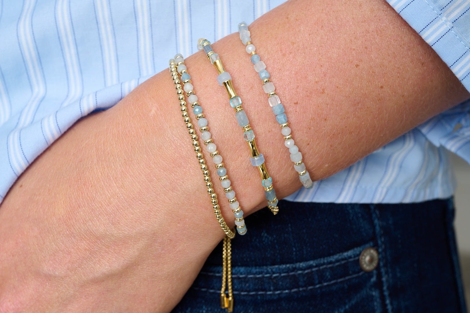 Delgadito aquamarine and gold stacking bracelets styled with denim, cool blue gemstones and golden shimmer for relaxed-luxe glow.