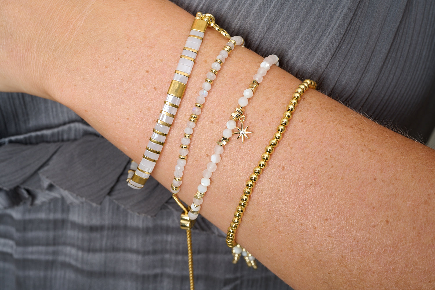 Delicado Gold & White Tila Bracelet styled with gold and white striped beads in a chic boho bracelet stack.