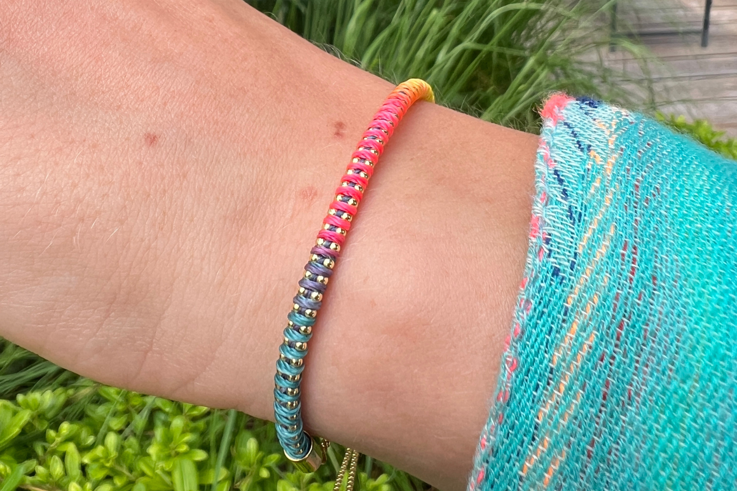Emelia Havana Brights Gold Braided Bracelet styled on the wrist, showcasing colourful woven threads and warm 14k Gold PVD details for effortless summer layering.