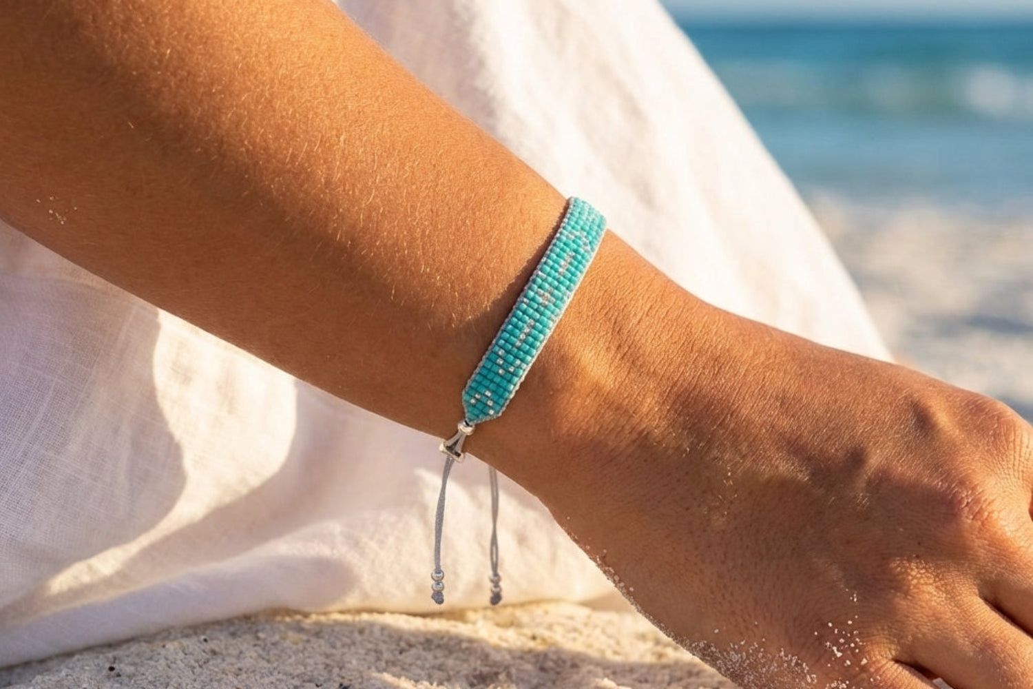 Close-up of our grace silver and turquoise beaded friendship bracelet showcasing just how much it matches summer vibes!