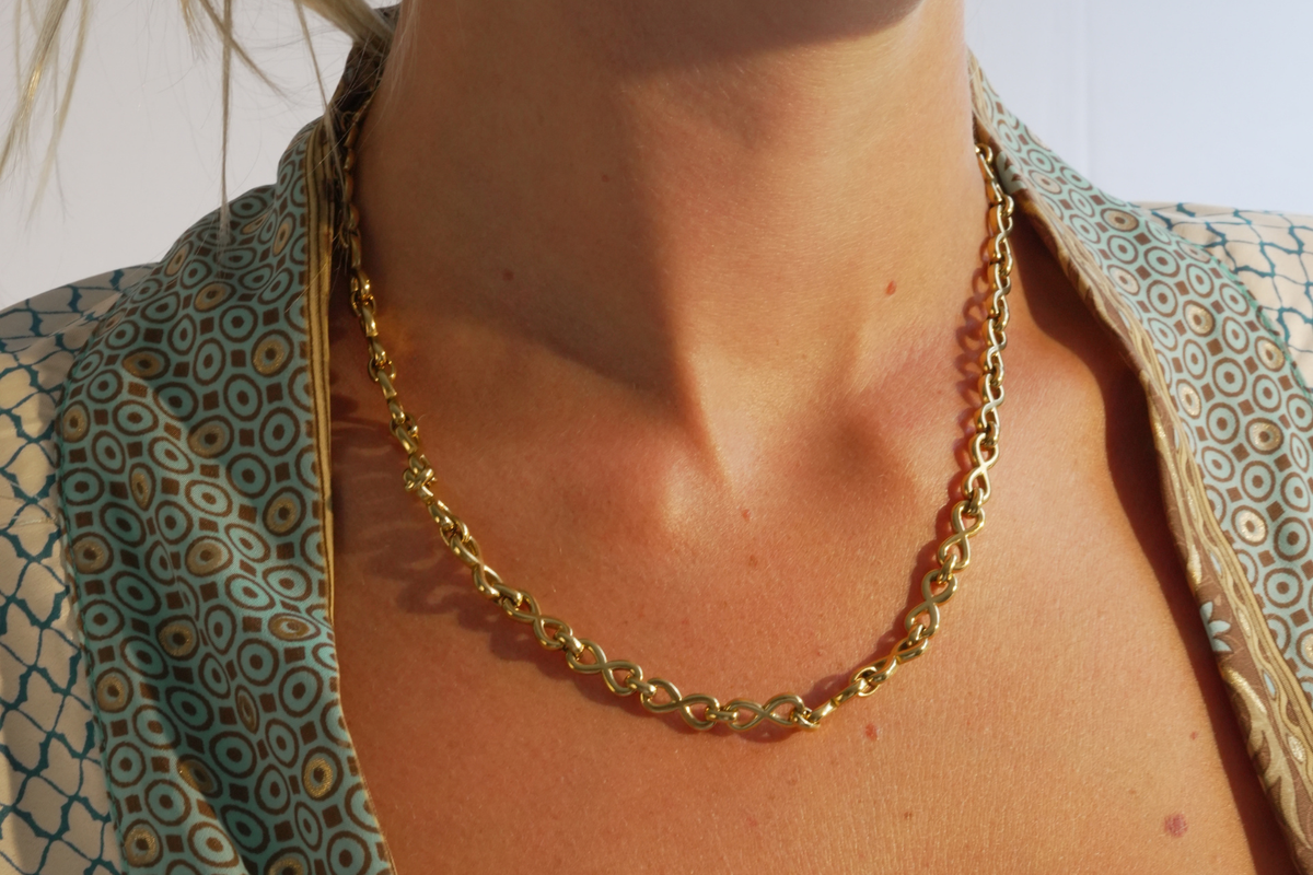 Hachi Gold Infinity Link Necklace featuring chunky polished infinity links, a waterproof 14k Gold PVD stainless steel finish and an adjustable lobster clasp fastening.